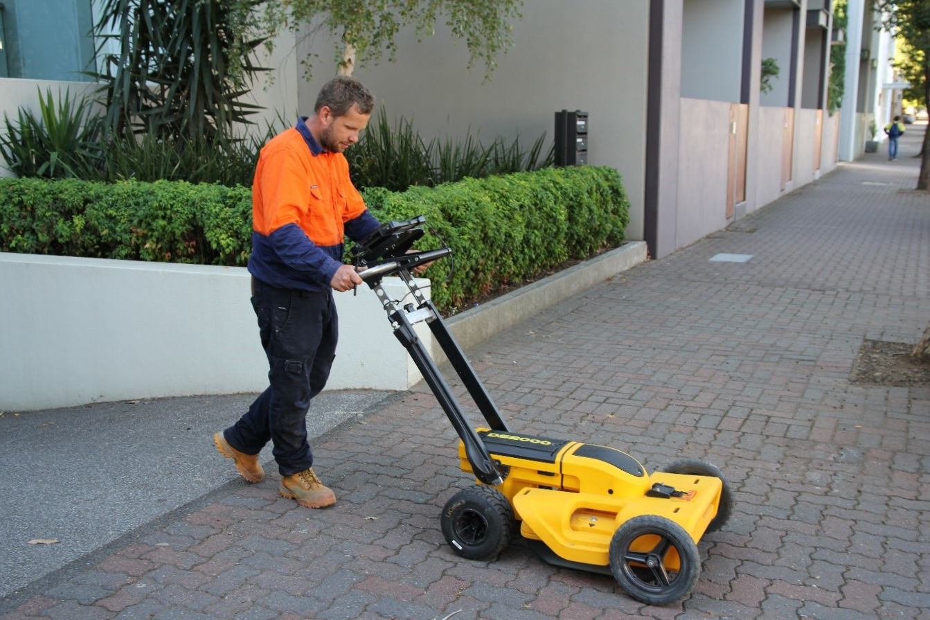 A man using a device to locate underground services